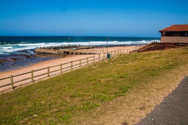 Çimen yolu ile kumsal arasında gelgit havuzlu ahşap çit