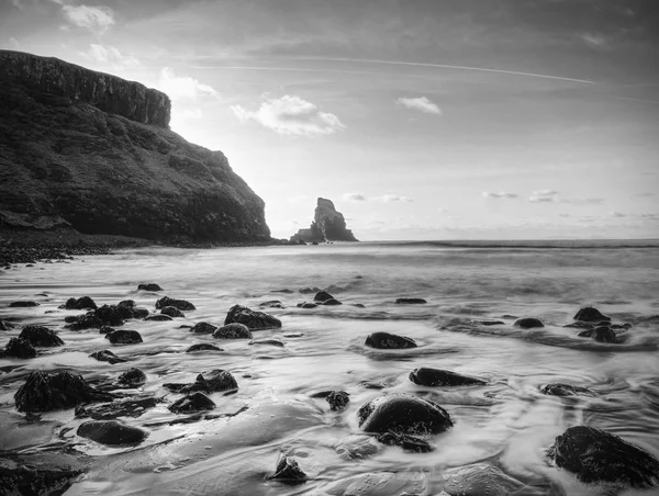 The rest of the day in rocky bay. Evening light on the rocks, boulders and cliff face of Talisker Bay, Isle of Skye