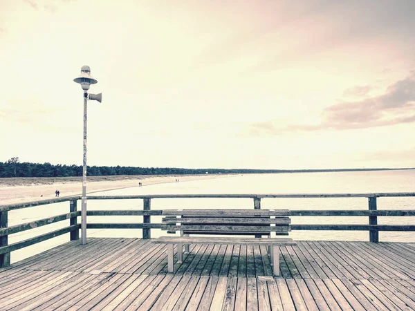 City wooden ocean pier for tourist against  misyt sky. Travel destinations concept. Wood bridge pier with romantic morning view, natural background.