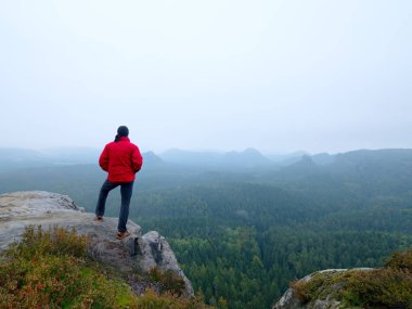 Adam turist hiker veya iz runner yüksek dağlarda ilham verici kayalık manzara bakarak. Kayalık dağ tepesine üzerinde manzarayı erkek atlet