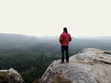 Adam turist hiker veya iz runner yüksek dağlarda ilham verici kayalık manzara bakarak. Kayalık dağ tepesine üzerinde manzarayı erkek atlet