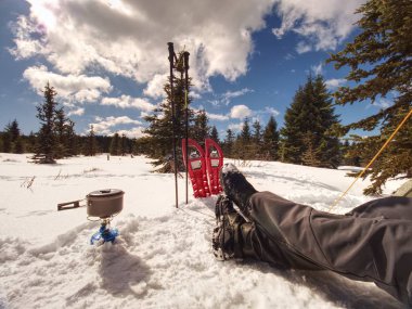 Karda çadır önünde yemek kış ormanda kamp. Bir şenlik ateşi kamp ateşi yapma ve yemek yemek ile taşınabilir Ocak ve yangın, karlı manzara