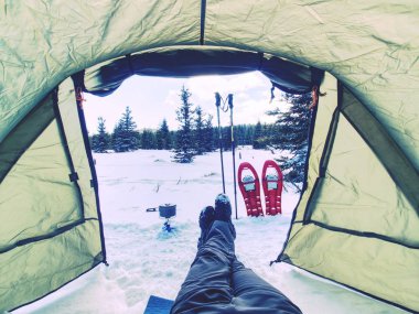 Adam rahatlatıcı. Kamp çadır giriş kış manzara karlı manzara için. Yaşam tarzı kavramı, kar dağlar seyahat. Yürüyüşçüler kış tatili