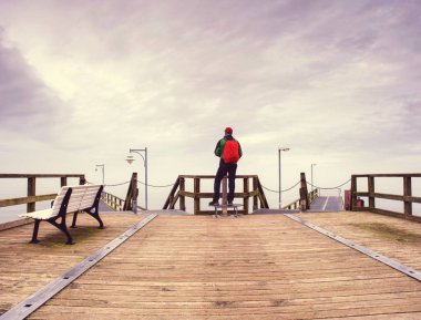 Adam gezgin iskelenin ucunda uzak ufuk dikkat et. Moody sabah deniz Köprüsü