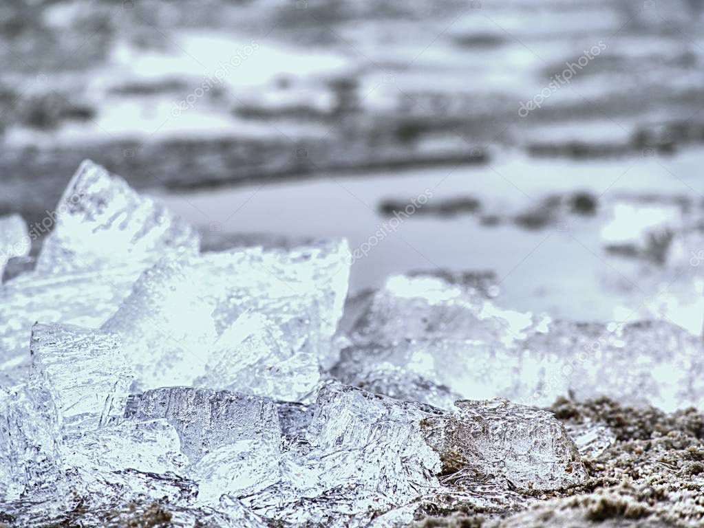 Pieces of clear natural ice on frozen lake,  very close up view. Early mealting of ice, ecology problem.