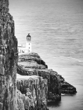 Neist noktası Yarımadası ile deniz feneri, turizm Isle of Skye, İskoçya üzerinde. Köpüklü mavi deniz keskin uçurum karşı grev. Tüm yolcuları görmek gerekir