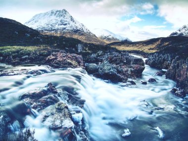 Havuzları ve majestatic şelaleler belllow karlı dağlar. Mavi su mirrorong mavi bulutlu gökyüzü