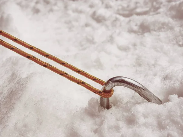 Chrome steel hook anchor camping tent in snow. Process of installing tent setting up tent outdoors.