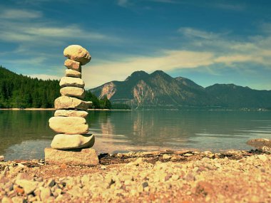 Mavi su dağ Gölü'nün kıyısında taş pyramide dengeli. Su seviyesi ayna Blue mountains.