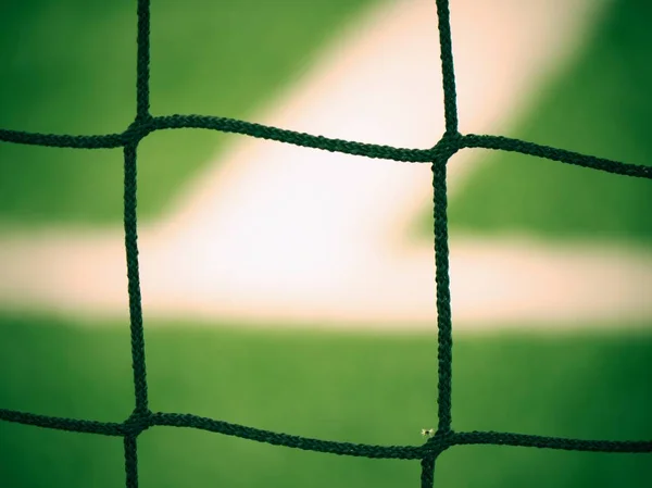 Hang bended white black soccer nets soccer football net. Grass on football playground in the background