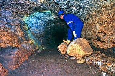 Adam mistik antik uzun tünelde turuncu kumtaşı duvarları, gelen şehir yeraltı çalışıyor. İç Kale catacombs, taş tünelden görüntülemek 