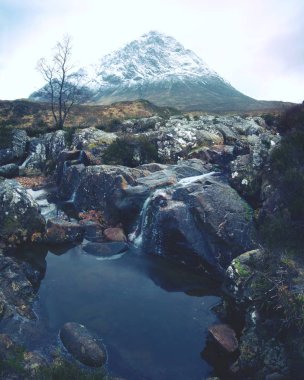 Buachaille Etive Mor nehir Glencoe İskoç dağlık yakınındaki Coupall yanında. Güneşli kış günü.