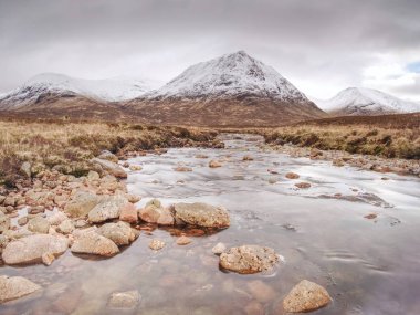 Buachaille Etive Mor nehir Glencoe İskoç dağlık yakınındaki Coupall yanında. Güneşli kış günü.