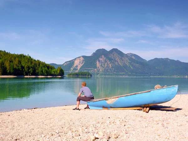 Man Sitting Stony Bank Alpine Mountain Lake Anchored Laminated Boat — Stock Photo, Image