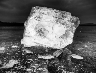 Karanlık doğal zemin üzerine kırılmış buz parçası. Siyah ve beyaz bir buz karanlık parçası döşeme otantik doku