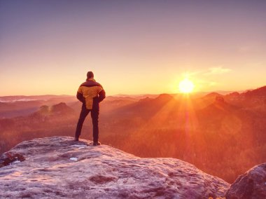 Adam dağın zirvesinde. Uzun yürüyüşe çıkan kimse rock sisli vadinin yukarıda zirvesine tırmandı. Turizm peyzaj üzerinde batımını yalnız