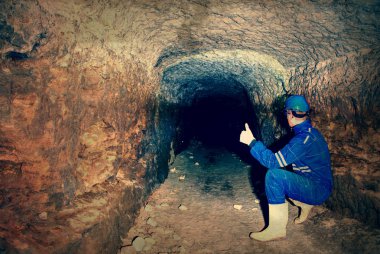 Workerman kask ve koruyucu elbise glowes ve güçlü kafa lambası kullanarak. Dostum bir şey terk edilmiş bir madende