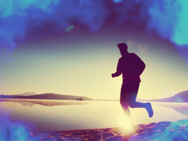 Sporcu parkta uzanan yapıyor. Siluet güneş, spor kavram karşı. Hipster filtre. 