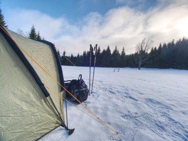 Kar altında yürüyüş çadır ile manzara. Yeşil çadır ve sabah ışık donmuş gölün yüzeyinde