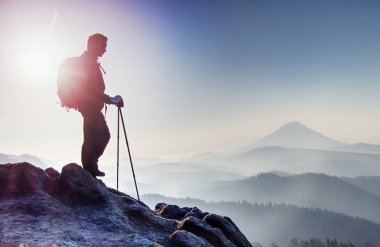 Uzun uzun yürüyüşe çıkan kimse sırt çantası ve trekking Polonyalılar ile dağ yolu yürümek. Yol mesafe içine manzaralı kayalık parçası. Dağlık manzara körük.