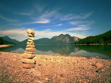 Mavi su dağ Gölü'nün kıyısında taş pyramide dengeli. Su seviyesi ayna Blue mountains.