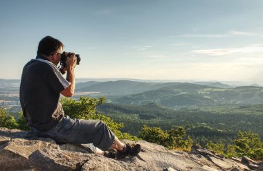 Doğa fotoğrafçısı dağlarda görünümü noktasında sanat oluşturun. Borning gün şaşırtıcı fotoğraf çekici adam onun büyük kameranın vizör arıyor.