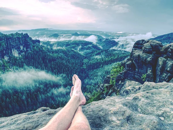 Çapraz bacakları yorucu dağ izi biraz dinlen. Pantolon dağ Vadisi yukarıda tepe üzerinde rahatlatıcı olmadan terli erkek ayakları.