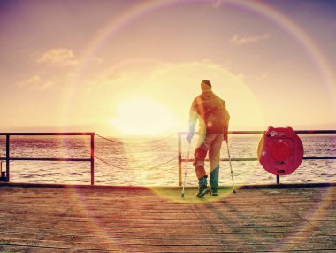 Polonyalılar ve feribot için bekleyen sırt çantası ile bekleyen adam. Gündoğumu ile dramatik gökyüzü