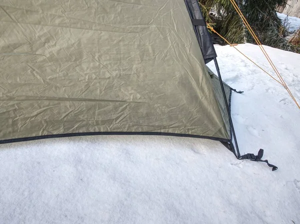 Winter camp by the lake in winter at dusk. Winter adventure with oversleeping in wild nature.