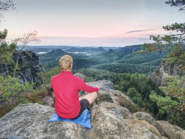 Arkadan Görünüş güzel güneş doğarken rock yoga meditasyon uygun biri. Güzel manzara orman manzara ile. Sağlıklı ve aktif yaşam tarzı.