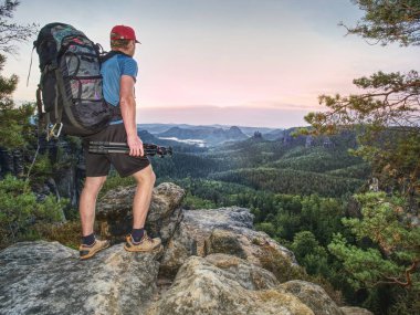 Manzara fotoğrafçı dağlar kamera alır etkileyici fotoğraflar puslu düşmek için hazırlayın. Keskin kayalık kenarında turistik fotoğrafçı