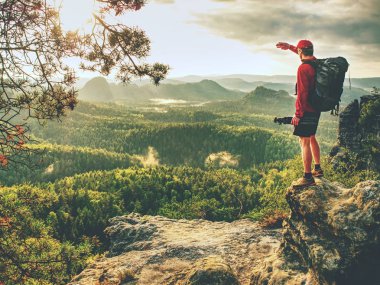 Amatör fotoğrafçı. Gün batımında dağın zirvesinde elinde büyük kamera günlüğü ve bazalt tripod ile turist fotoğrafçı. Yaz aylarında açık havada seyahat