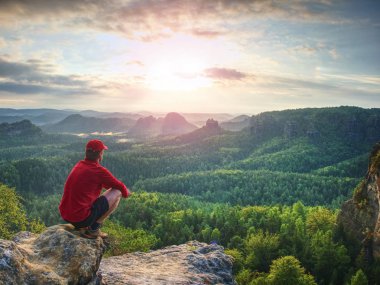Başarı adam bir zirvesinde peyzaj gözlemlemek. Genç dağcı veya uzun yürüyüşe çıkan kimse kayalık bir tepe üzerinde uygun