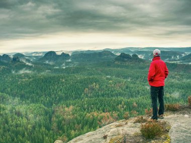 Puslu manzara görünümü puanın altına bakan için bir an için adam kalış. Bir uçurumun kenarında iz 