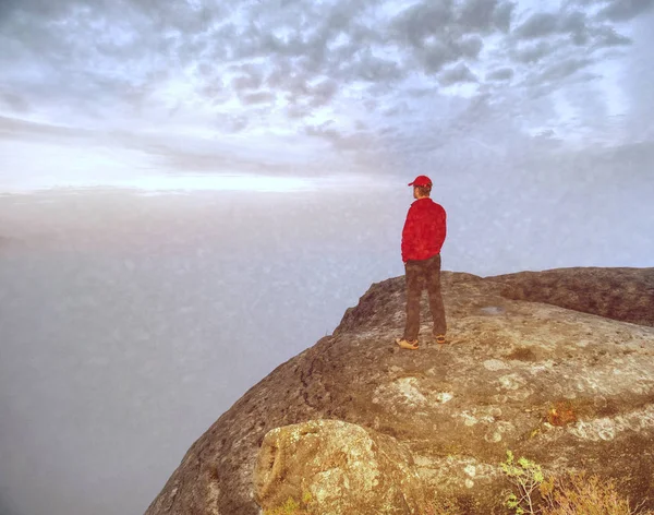 Gloomy nostalgic view into fall nature with lonely melancholic adult man. Sportsman without  jacket standing on the top  in misty morning and thinking