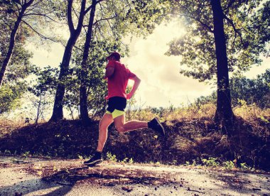 Sporcu adam çalıştıran. Erkek atlet açık havada için maraton koşmak eğitim sırasında Sprint. Atletik uygun genç spor fitness modeli, dışarıda Sonbahar Doğa ıslak yol.