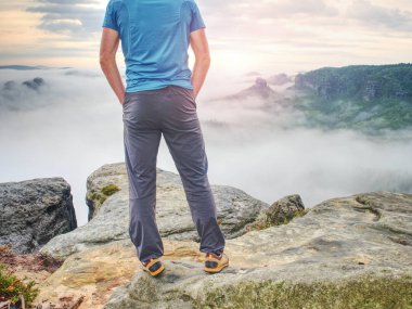 Elleri cebinde, yakışıklı adam uçurumun kenarına uzak duran arıyorum. Kırmızı beysbol şapkası ve açık moda giysiler giyen genç adam