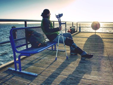 Polonyalılar ve feribot için bekleyen sırt çantası ile bekleyen adam. Gündoğumu ile dramatik gökyüzü