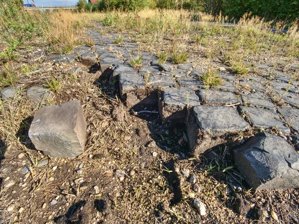 Ruined old cobble stone way. Paving Stones Road. Crawl destroyed urban sidewalk construction stones
