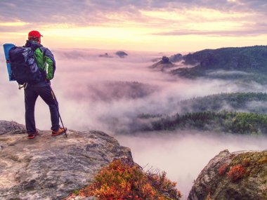 Adam gözlemlemek daybreak rock İmparatorluğu'nun peak düşmek. Rüya gibi sisli manzara bahar bir güzel vadi Saksonya'nın İsviçre parkta turuncu pembe puslu gündoğumu.