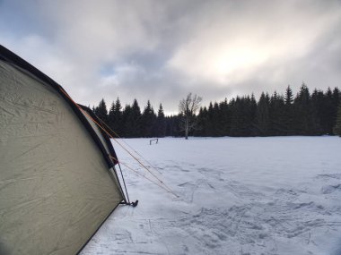Aşırı kış koşullarında hafif yeşil çadır. Yüksek dağlarda kar ile kaplı manzara.