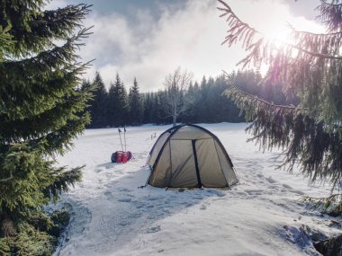 Aşırı kış koşullarında hafif yeşil çadır. Yüksek dağlarda kar ile kaplı manzara.