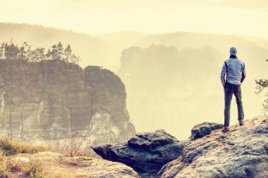 Puslu Vadisi yüksek bir uçurumun kenarında yürüyen adam. Hiking seyahat ve yaşam tarzı. Kişisel başarı kavramı, macera aktif tatiller açık