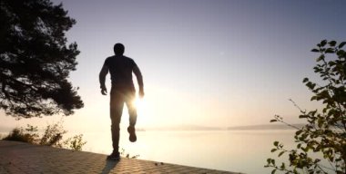 Spor spor saati kontrol zamanı dostum. Dağ Gölü akşam güneşi karşı egzersiz, runner.