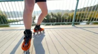 Satır içi roller skater bacaklarını kapat. Göl köprü yolda sert kabuğu yüksek teknoloji paten buz pateni. 