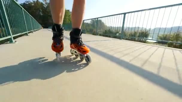 インライン ローラー スケート選手足のクローズ アップ 湖橋道路上でハードシェル ハイテク スケートのスケート — ストック動画