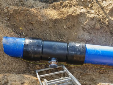 Yeraltı su boru hattı süreci onarılıyor. Mavi plastik tüpler açması ile birlikte ortak üye ve vida flanş ile plastik borular kaynaklı.