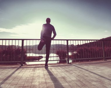 Egzersiz koşucu. İnsan şey germe, deniz kenarındaki güzel Çalıştır dışında bir mola. Genç caucausian atletik modeli eğitim maraton açık havada için uygun