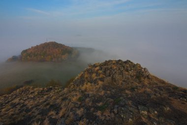 Daybreak ile kayalık tepe. Dolunay gece biter ve güneş sis tepelik ufuk yukarıda yer aldı