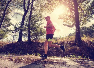 Sporcu adam çalıştıran. Erkek atlet açık havada için maraton koşmak eğitim sırasında Sprint. Atletik uygun genç spor fitness modeli, dışarıda Sonbahar Doğa ıslak yol.